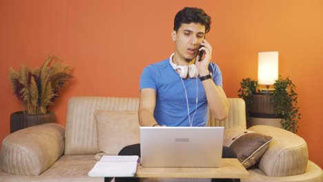 Man-using-laptop-nervously-talking-on-the-phone.